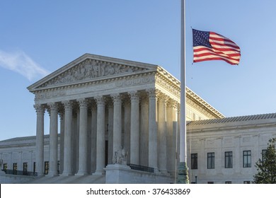 WASHINGTON, DC, USA - FEBRUARY 14, 2016: Flags fly at half-staff at the United States Supreme Court as the sun rises on the first day after Justice Antonin Scalia's death was announced.  