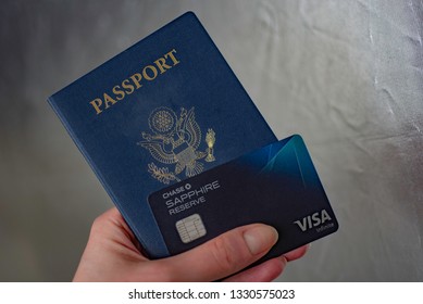 Washington, DC, USA - February, 27, 2019: Passport Of USA And Chase Sapphire Ultimate Rewards Reserve Visa Credit Chip Card In Hand On Silver Blurred Background. 