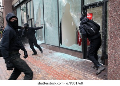 Washington, D.C., USA - January 20, 2017:  Anti-fascist, anti-Donald Trump demonstrators break the windows of a Bank of America and a Starbucks during a march through downtown.