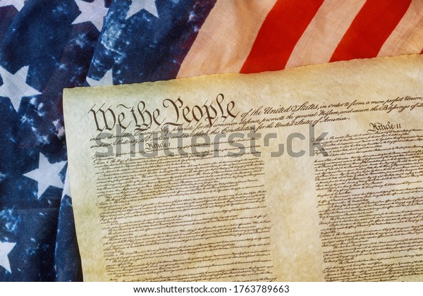 WASHINGTON D.C., USA - JUNE 25, 2020: Closeup\
of a replica of U.S. Constitution document of grunge American flag\
on We the people Bill of\
Rights