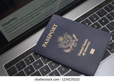 Washington, DC, USA - June, 28, 2018: Global Entry (TSA Pre Check) Website's  Fragment Next To Passport Of USA On Laptop  (notebook) Keyboard. Trusted Traveler Programs. Online Travel Concept. 