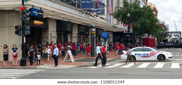 WASHINGTON DC, USA - JUNE 7, 2018: Fans lined up\
for a Capitals hockey game with police car barricading the street\
in preparation for\
events.