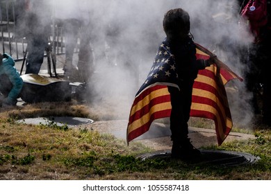  Washington DC / USA - March 24, 2018: Young Boy Draped In The American Flag Standing Over Steam At The March For Our Lives