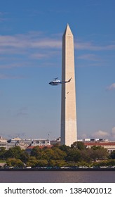 WASHINGTON, DC USA - OCTOBER 4, 2011: U.S. Government Helicopter Passes Washington Monument. Two Engineers Climb On Monument To Inspect For Earthquake Damage..