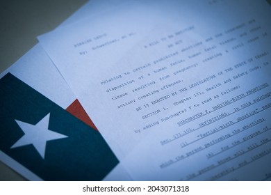 Washington, DC, USA - September, 9, 2021: Blurred Close up view of Texas Abortion Law next to the flag of Texas