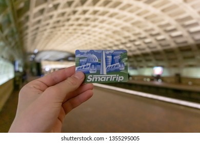 Washington, D.C./USA- March 31st, 2019: A Young Teenage Male Holding Up A Smartrip Card At A Underground Metro Station.