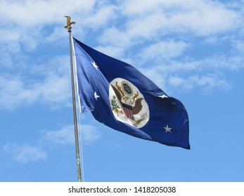 Washington, DC/USA-June 6, 2019: A Blue Flag With The Official Seal Of The U.S. Government Flies Over The Headquarters Of The Department Of State In Foggy Bottom. 