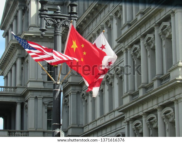 Washington, DC/USA-Sept. 24, 2015: The flags of\
China, the U.S. and the District of Columbia hang outside the Old\
Executive Office Building in preparation for a state visit by\
President Xi\
Jinping.