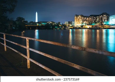 The Washington Monument And Buildings Along The Waterfront At Night In Washington, DC.