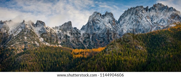 Washington Pass Along\
the North Cascades Highway During the Autumn Season. Larch trees\
and snow on the hills signal the approach of winter in the North\
Cascade Mountain\
range.