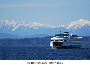 Washington State Ferry cruises in front of Olympic Mountains on approach to Seattle