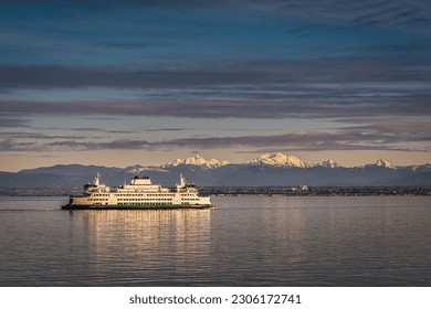 A WASHINGTON STATE FERRY IN THE PUGET SOUND WITH A NICE REFLECTION AND THE OLYMPIC MOUNTIANS IN THE BACKGROUND - Powered by Shutterstock