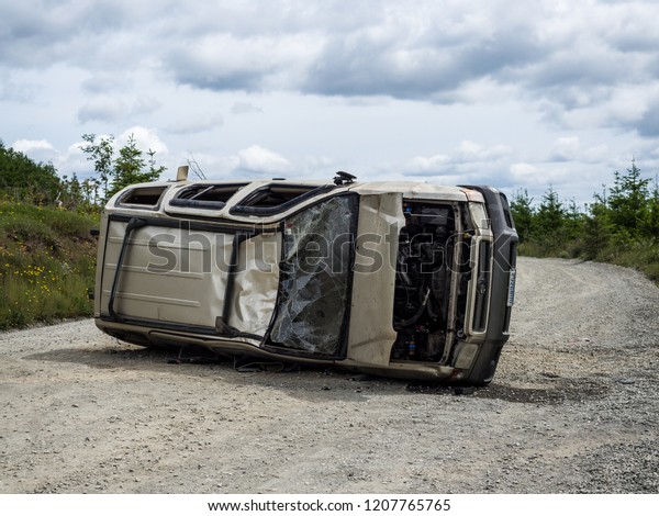 Washington\
State, USA - June 1, 2018: Car turned on the side after an accident\
on a rural road in Washington State,\
USA