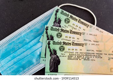 Washington, Usa - 10 March 2021: Close Up Of Stimulus Check And Face Mask On Black Background, Concept Of Federal Financial Help Given To Stop Economic Crisis Of Covid19 Pandemic