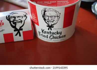 WASHINGTON, USA - JUNE 11 2022 : KFC Global Fried Chicken Meal Set, Kentucky Fried Chicken, Bucket Meal, Large Takeaway Chicken Set With Paper Bag Put It On The Red Table.