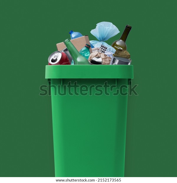 Waste bin full of mixed\
undifferentiated garbage, improper waste management\
concept