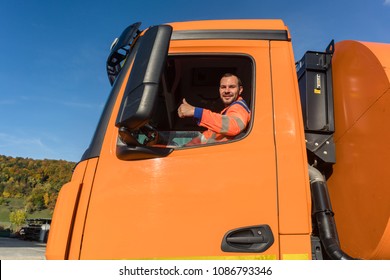 Waste Collector Driving Garbage Truck Giving Thumbs Up From The Window