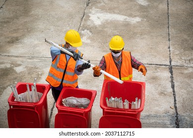 Waste Collectors At Work,Garbage Removal Worker In Protective Clothing Working For A Public Utility Emptying Trash Container.