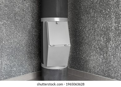 Waste disposal container installed on the floor of a multi-storey building on the grey background. Cleaning and maintenance concept trash and linen and chute systems. 