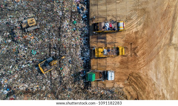 A lot of waste is disposed of in the waste disposal\
pits. Loaders is working on a mountain garbage. Aerial view and top\
view.