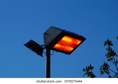 Waste Of Energy: A Floodlight Burns In Bright Sunlight   There Are So Many Ways To Reduce Energy Consumption 