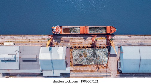 Waste loading at port, cargo ship transports containers of garbage for recycling factory. Plastic Pollution environment ocean.