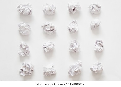 Waste recycling. Flat lay of crumpled paper ball rows on white surface. Abstract background.