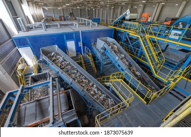 Waste sorting plant conveyors filled with various household waste. Modern waste processing. - Shutterstock ID 1873075639