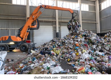 Waste Sorting And Recycling Plant. Loader And Grab Crane Are Handling Waste.