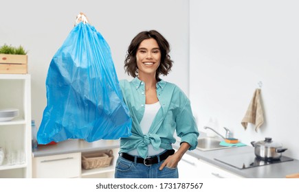 Waste Sorting And Sustainability Concept - Smiling Young Woman Holding Plastic Trash Bag Over Home Kitchen Background