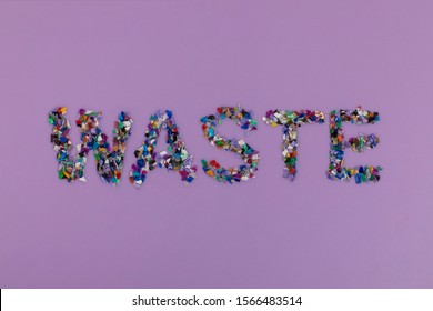 Waste Text Consisting Of Small Plastic Pellets Collected From The Sea Water. Rethinking The Environment By Reducing Or Reusing Plastics. Circular Economy Concept. Lilac Purple Background