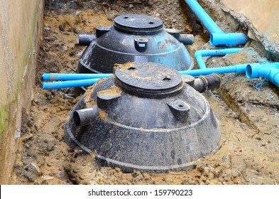 Waste treatment tanks and PVC pipes are installed into the ground.  - Shutterstock ID 159790223