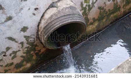 waste water flow to sewer with moss, bad water from city, water pollution, sewer drain pipe dirt sewage water drain