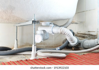 Waste Water Siphon Or Sink Drain Connected To The Bottom Of The Acrylic Tub. Installation, Cleaning And Repair Of Household Plumbing And PVC Plastic Sewer Pipes.