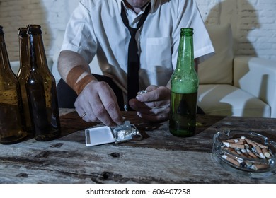 wasted alcoholic and drug addict man with loose tie snorting cocaine and drinking beer bottles at home living room couch in toxic substance addiction and abuse concept