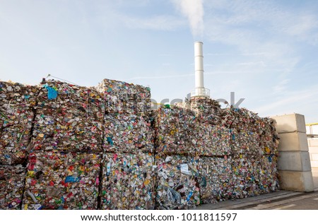 Waste-to-energy or energy-from-waste is the process of generating energy in the form of electricity or heat from the primary treatment of waste. Cubes of pressed metal beer and soda cans. Foto stock © 