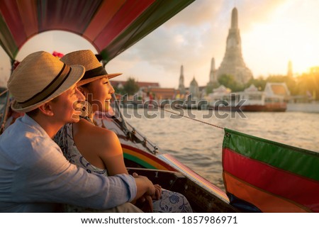Wat Arun Ratchawararam temple. Couple traveller with boat in the Arun temple, landmark thailand tourist spot, Bangkok city, Thailand