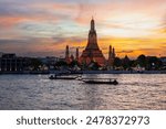 Wat Arun temple Bangkok during sunset in Thailand. Chao praya river Bangkok at dusk evening light with a colorful sky and light on the temple
