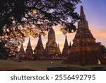 Wat Chaiwatthanaram temple at Ayutthaya in Thailand. Sunset scenery sky view in winter season. Tourism wearing traditional Thai clothing. Place of landmark popular of tourist.