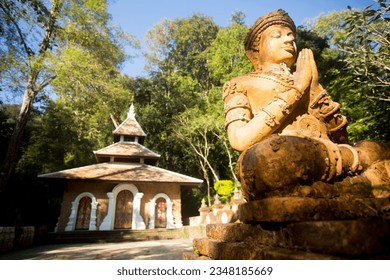 Wat Phra Lat in Chiang Mai. Temple of a Buddhist monastery with statues, hidden in the middle of the forest and accessed by a path.