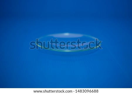 Watch glass is used for acid-base testing and for closing glass devices to prevent evaporation. Used in chemical laboratories. Close up blue background