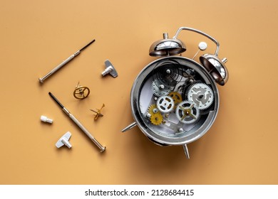 Watch Mechanism And Watchmaker Tools Near Open Alarm Clock