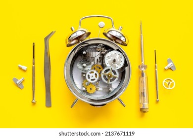 Watch Mechanism And Watchmaker Tools Near Open Alarm Clock