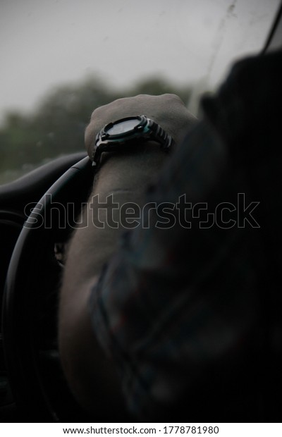 watch on hand, hand\
on the steering wheel