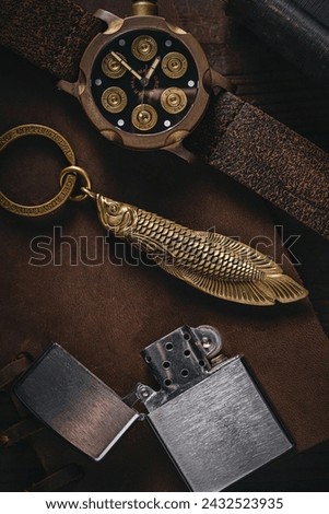 A watch shaped like magnum bullets, a key chain, and a lighter. All of these things look old. 