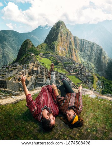 Watch this! Happy young tourist couple are on vacation, with ponchos in Machu Picchu
