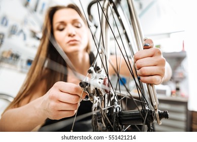 Watchful technician mending the bicycle in the repair shop - Powered by Shutterstock