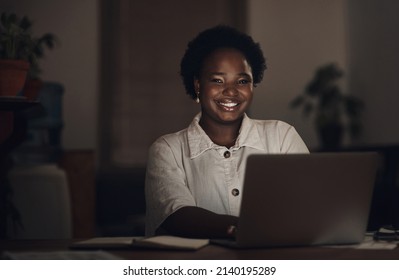 Watching The Clock Im Watching My Bank Balance Go Up. Portrait Of A Young Businesswoman Using A Laptop During A Late Night At Work.