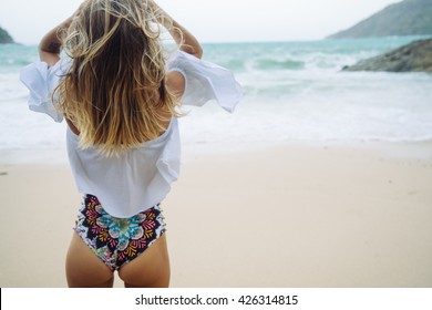 watching the coming sea storm - beautiful woman standing  on the beach. Blond hair with ombre coloring. Hipster toning. Soft focus. 