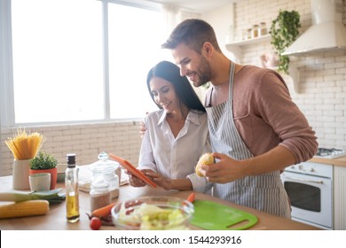 Watching culinary video. Husband hugging wife while watching culinary video on tablet together - Powered by Shutterstock